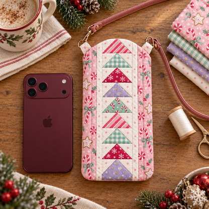 Sugarplum Stroll pink Christmas phone bag on an oak sewing table with coordinating fabric and sewing supplies