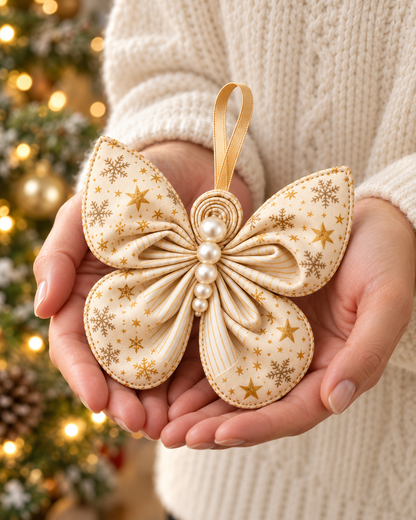 Hands holding a cream and gold star print fabric butterfly Christmas ornament with a gold ribbon hanger