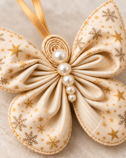 Close-up of a folded fabric butterfly ornament showing accordion pleats, striped lining and pearl bead body