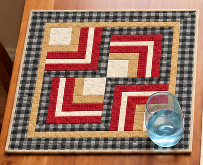 Buffalo Check Log Cabin farmhouse placemat with a water glass, showing four Log Cabin blocks rotated into a pinwheel