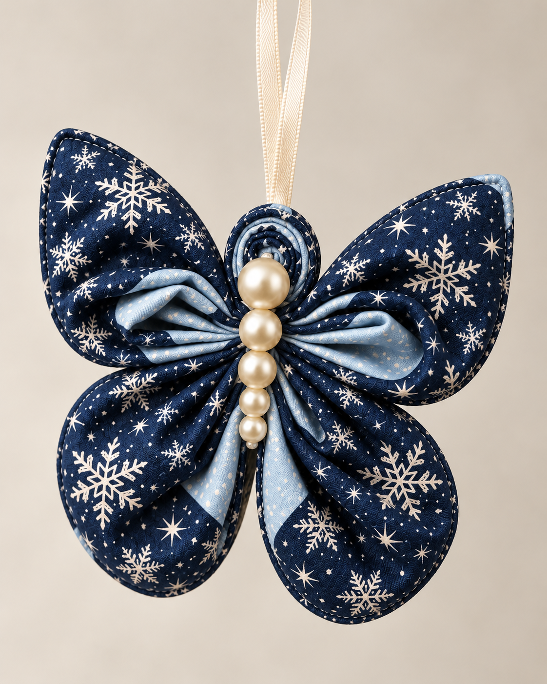 Navy blue snowflake fabric butterfly ornament with light blue lining and pearl body, sewing pattern sample