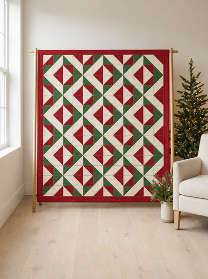 Christmas Evergreen quilt in red, green and ivory displayed on a wooden stand beside a Christmas tree