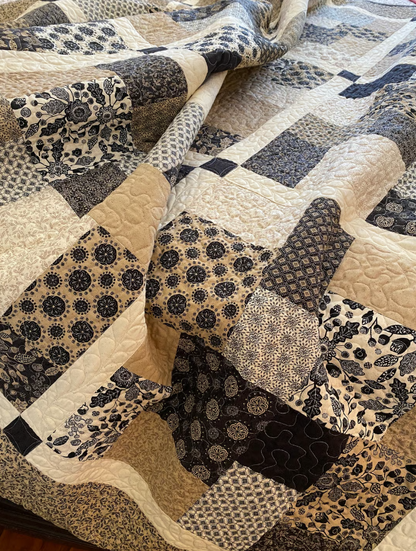 Close-up of Layer Cake Toss Quilt patchwork – navy and cream batik fabric squares with quilting detail