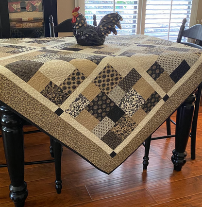 Layer Cake Toss Quilt draped over dining table – patchwork throw in neutral batik prints for home decor