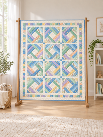 Pastel blue, mint and lilac diamond log cabin quilt beside a bright window