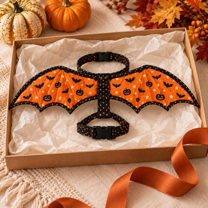 Pumpkin Flight fabric bat wing harness arranged in a kraft gift box with ivory tissue and an orange ribbon