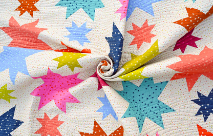 Starburst quilt fabric detail showing colourful bold stars swirled together – rainbow star patchwork quilt PDF pattern for all skill levels