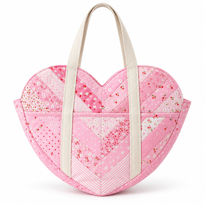 Front view of the pink Sweetheart heart-shaped patchwork shoulder bag with cream handles on an ivory studio background. AI-generated finished-sample illustration.