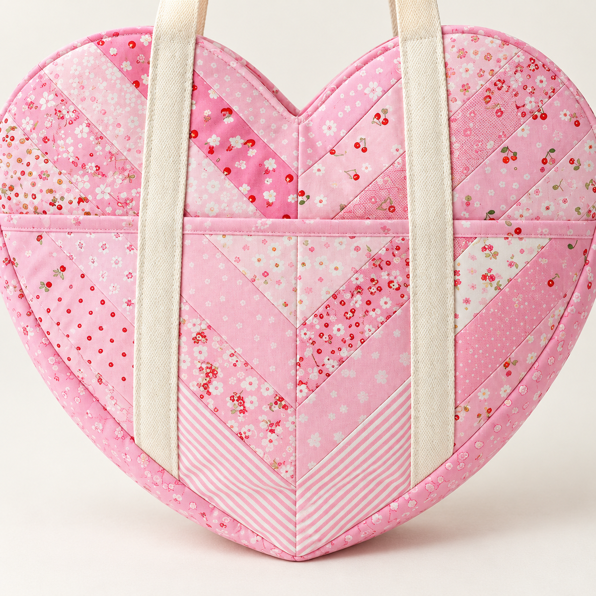 Close-up of the Sweetheart bag heart pocket with pink binding and chevron patchwork cotton. AI-generated finished-sample illustration.