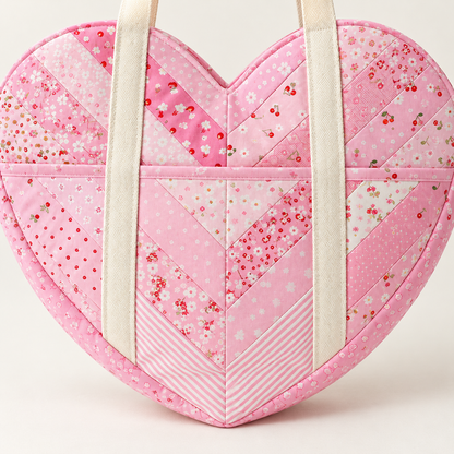 Close-up of the Sweetheart bag heart pocket with pink binding and chevron patchwork cotton. AI-generated finished-sample illustration.