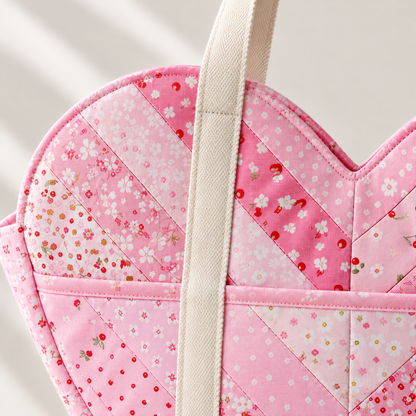 Close-up of cream handles, topstitching and pink patchwork on the Sweetheart shoulder bag. AI-generated finished-sample illustration.
